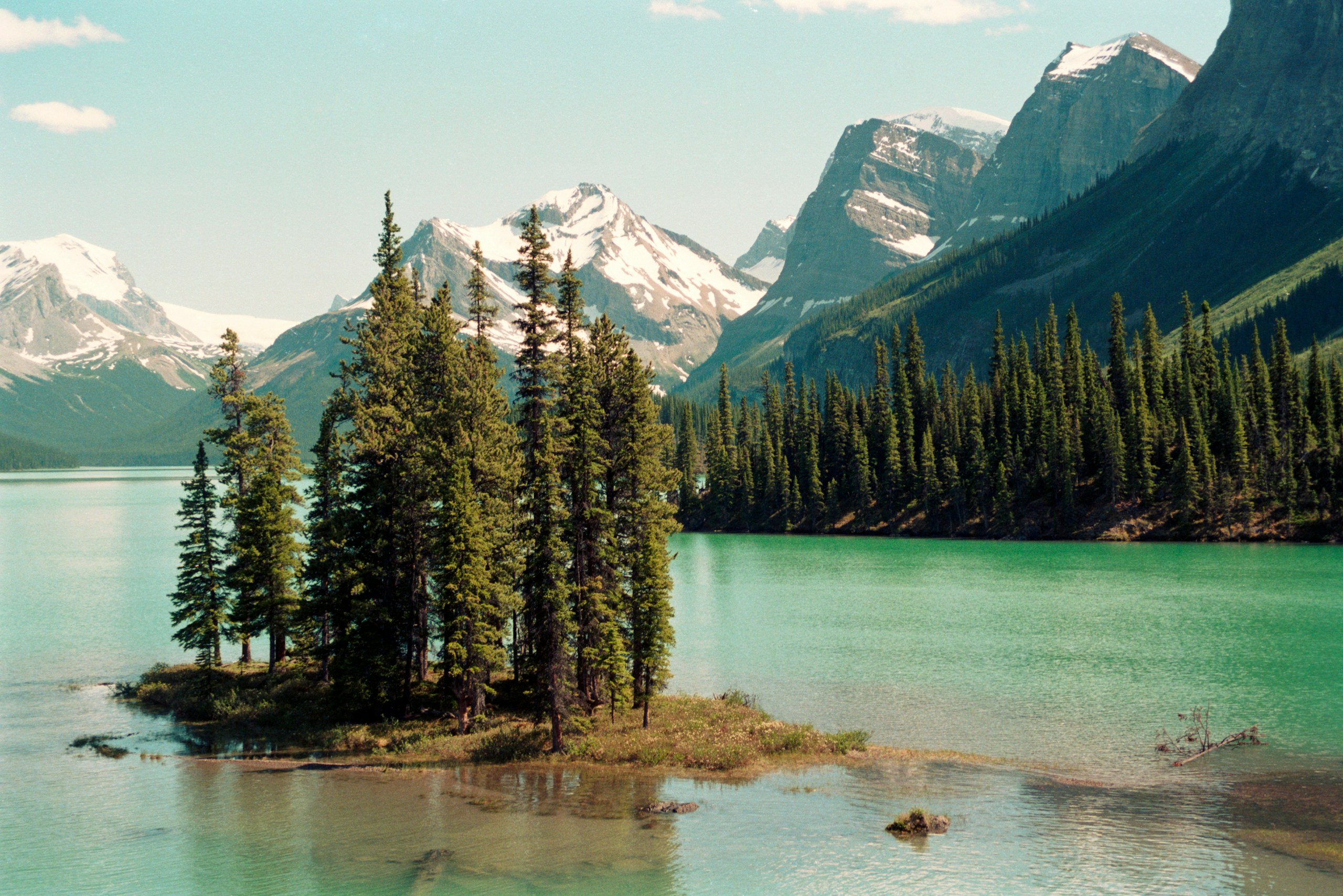 a small island in the middle of a lake surrounded by mountains