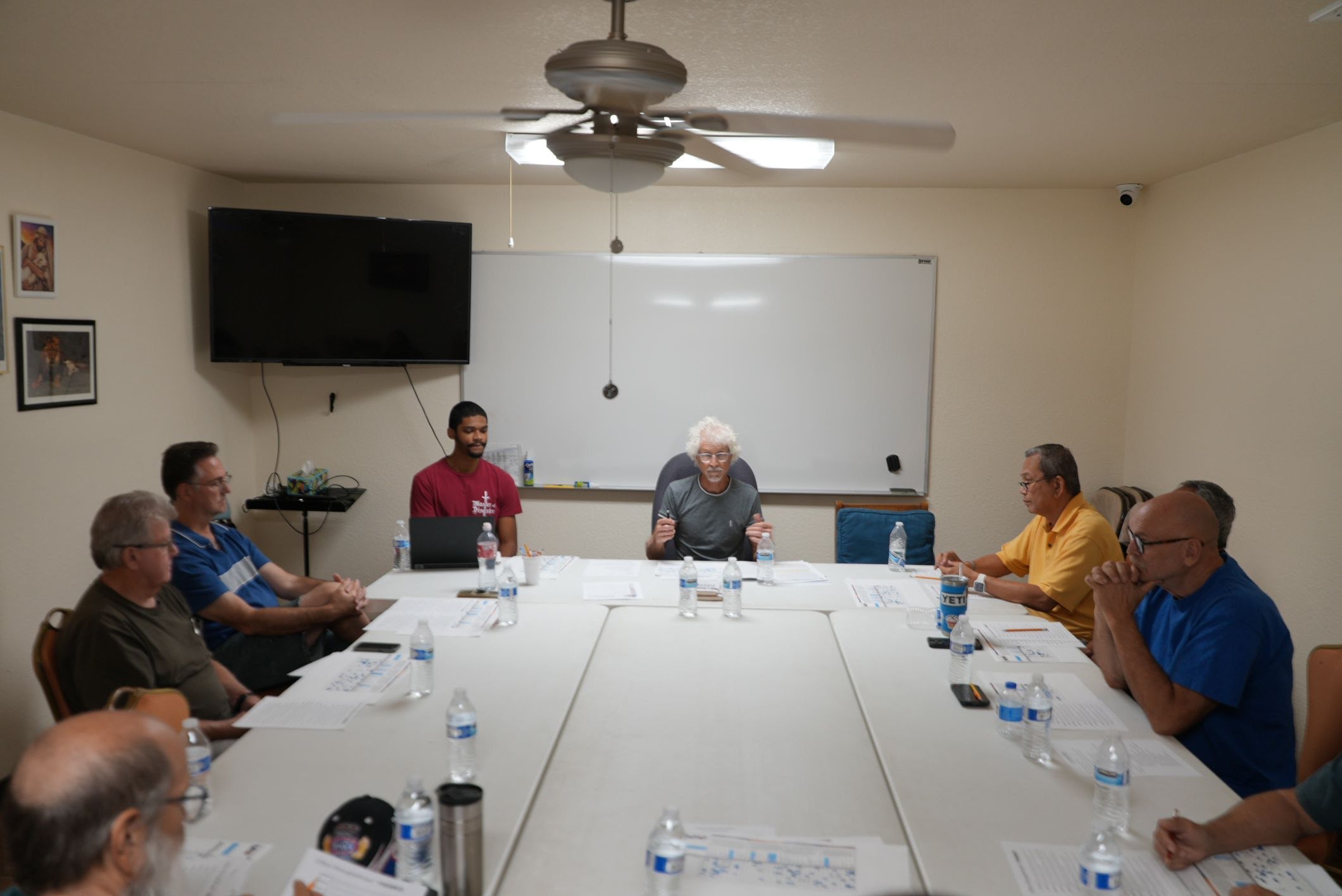 Men gathered around the table at an AJ SDA Men's Ministry meeting