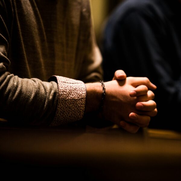 two people holding hands while sitting at a table
