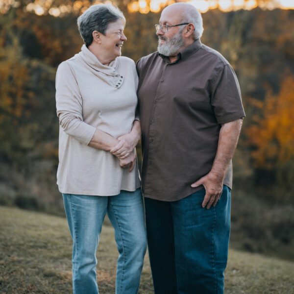 A man and woman standing next to each other in a field