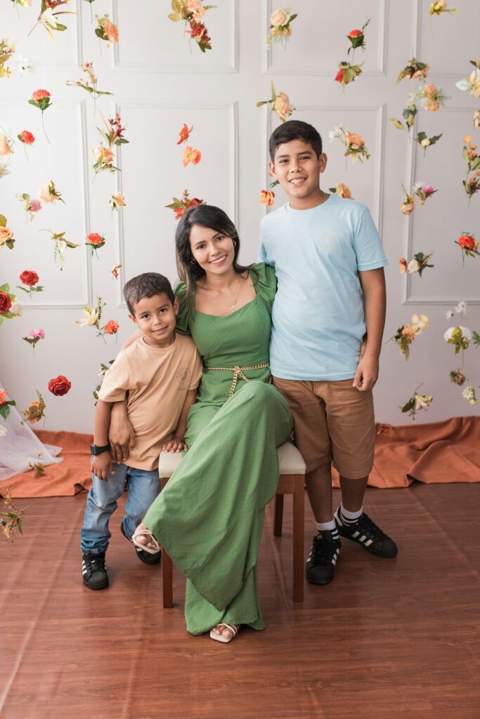 a family poses for a picture in front of a backdrop of flowers