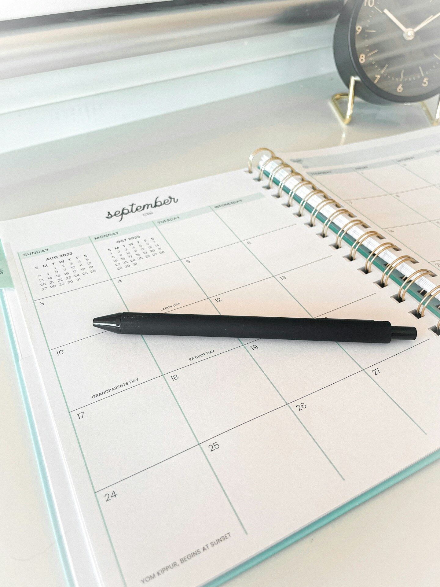 A black pen rests on an open september calendar.