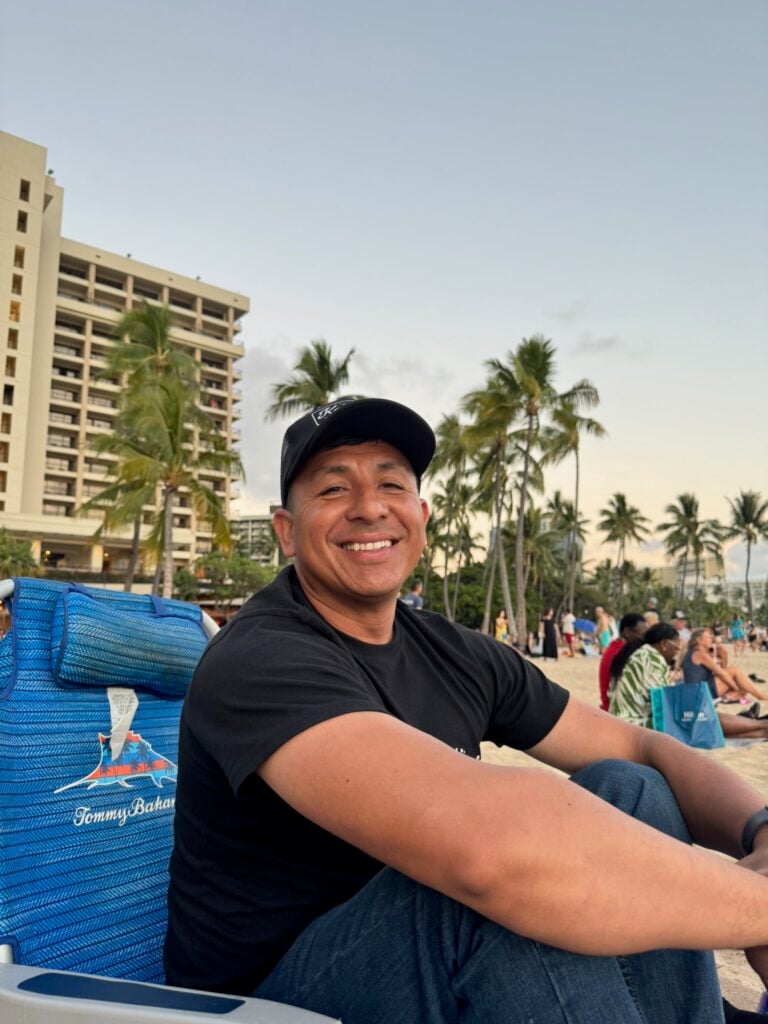 A BAA teacher relaxing outdoors near palm trees