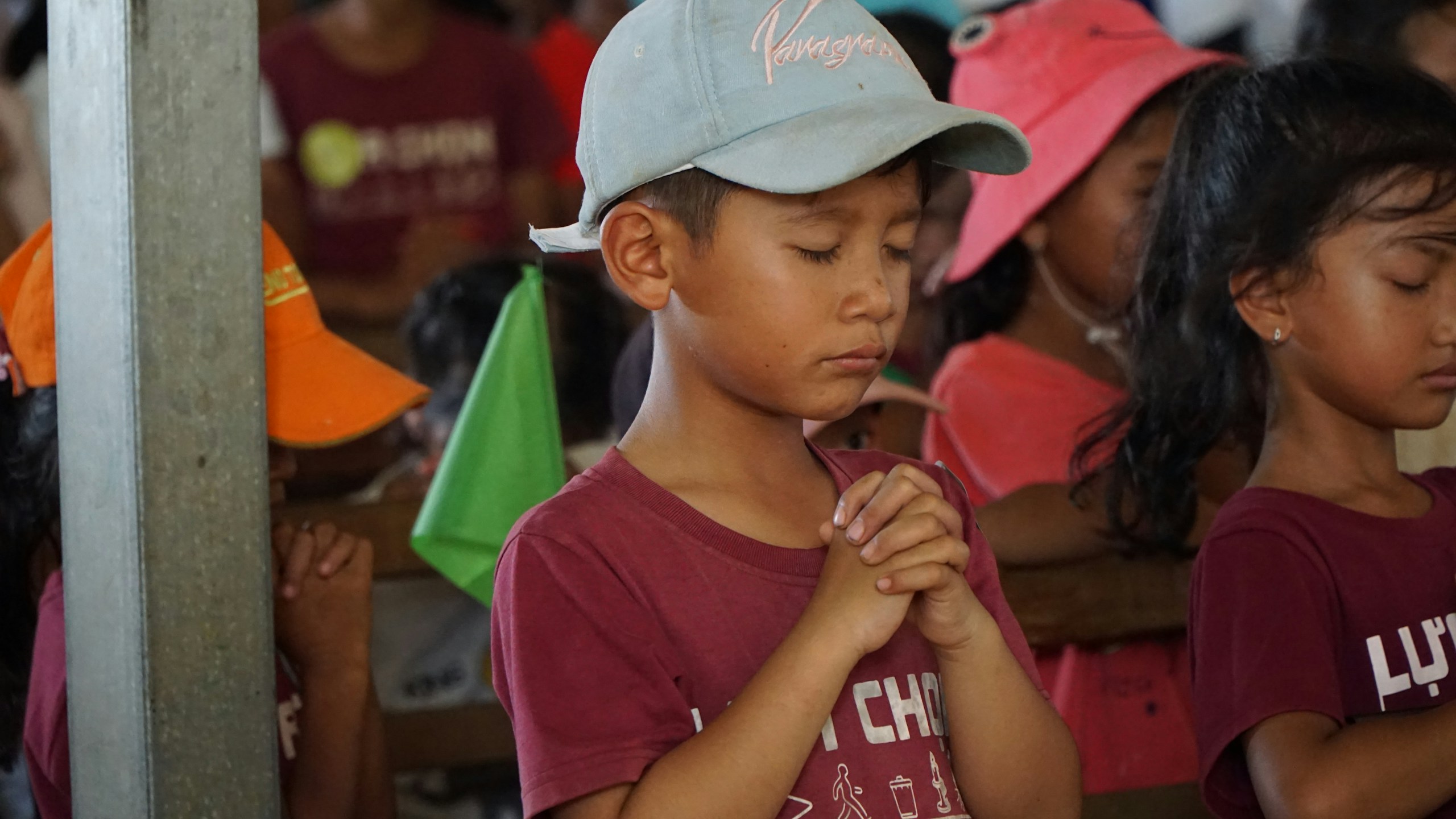 Children are praying with their hands clasped.