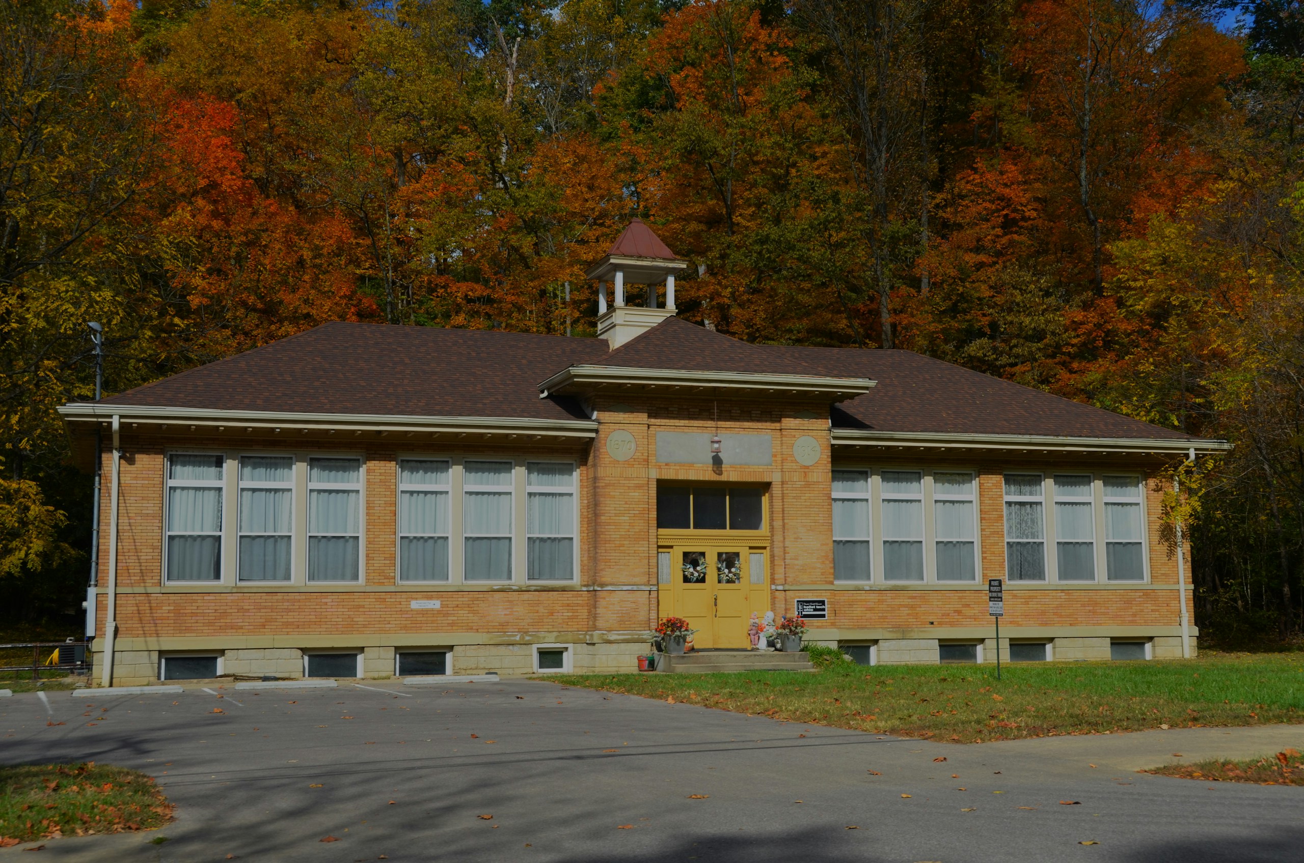 A school building with a clock tower in front of it