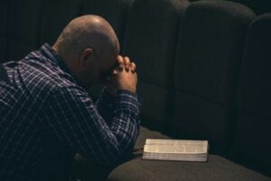 a man sitting on a couch with his hands on his face