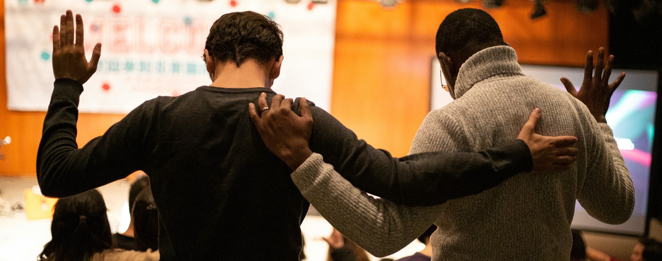 two men holding ear others hand
