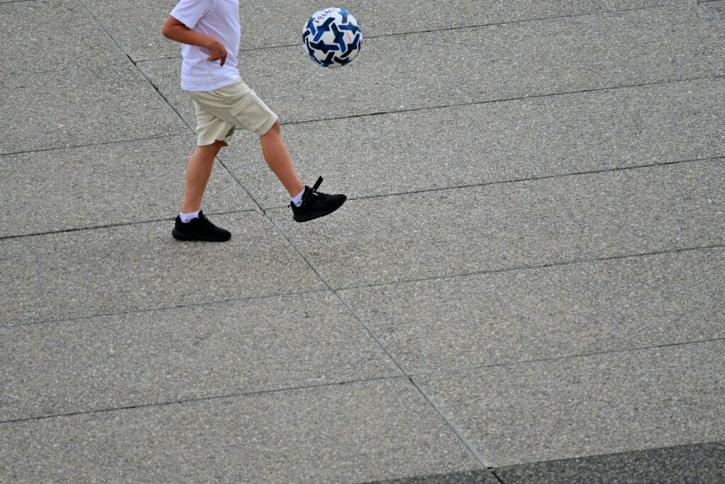 A young boy is kicking a soccer ball