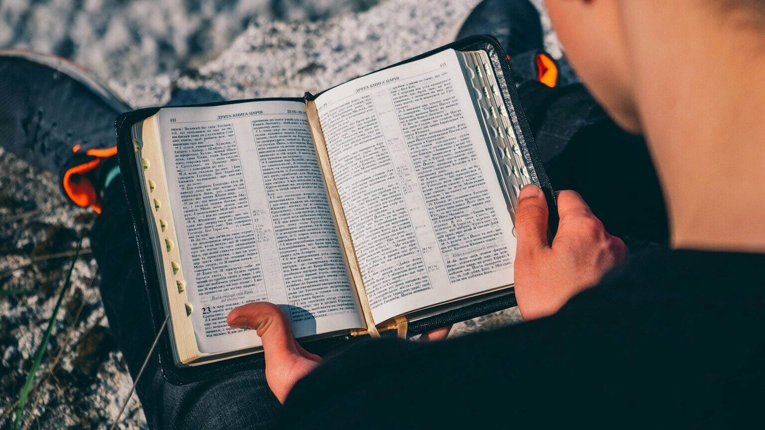 man in black jacket holding black and white book