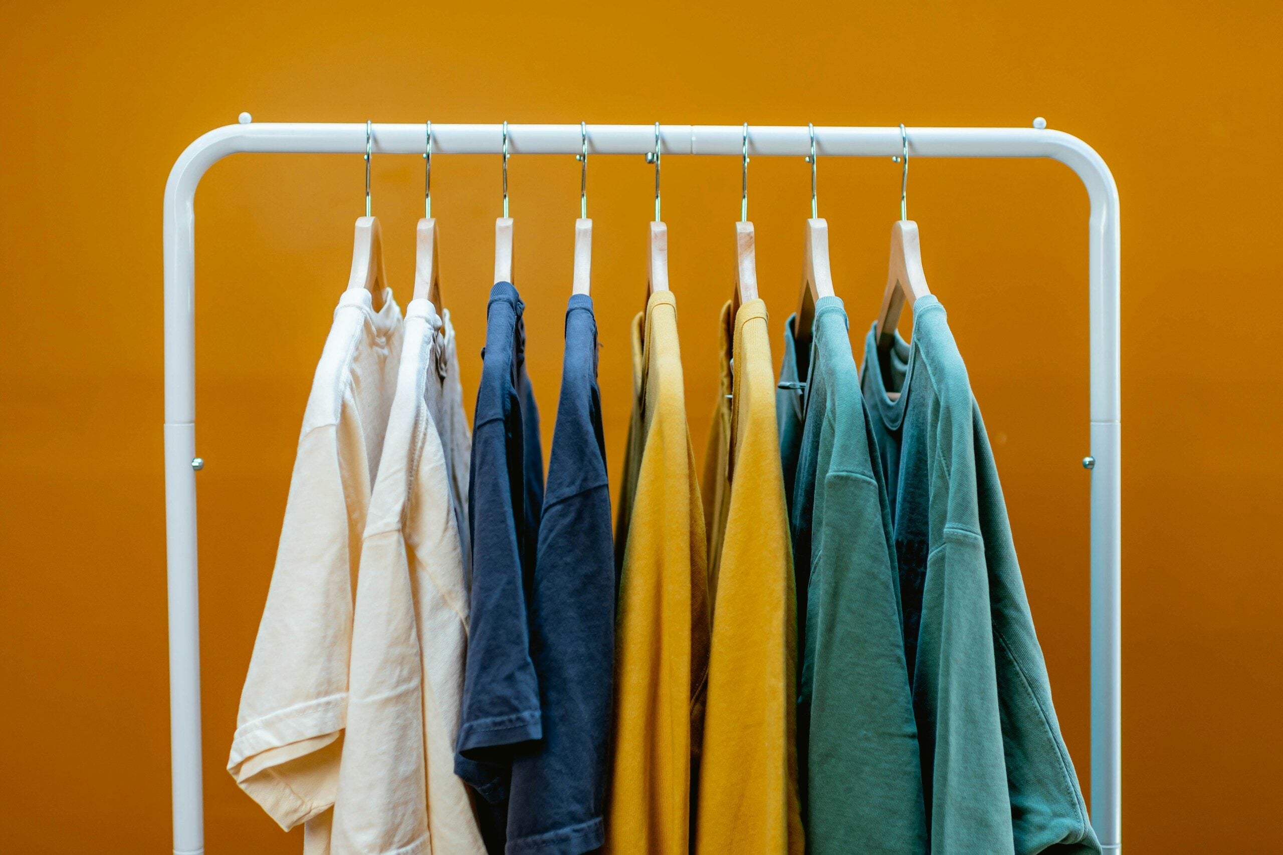 A rack that has a bunch of clothes hanging on it