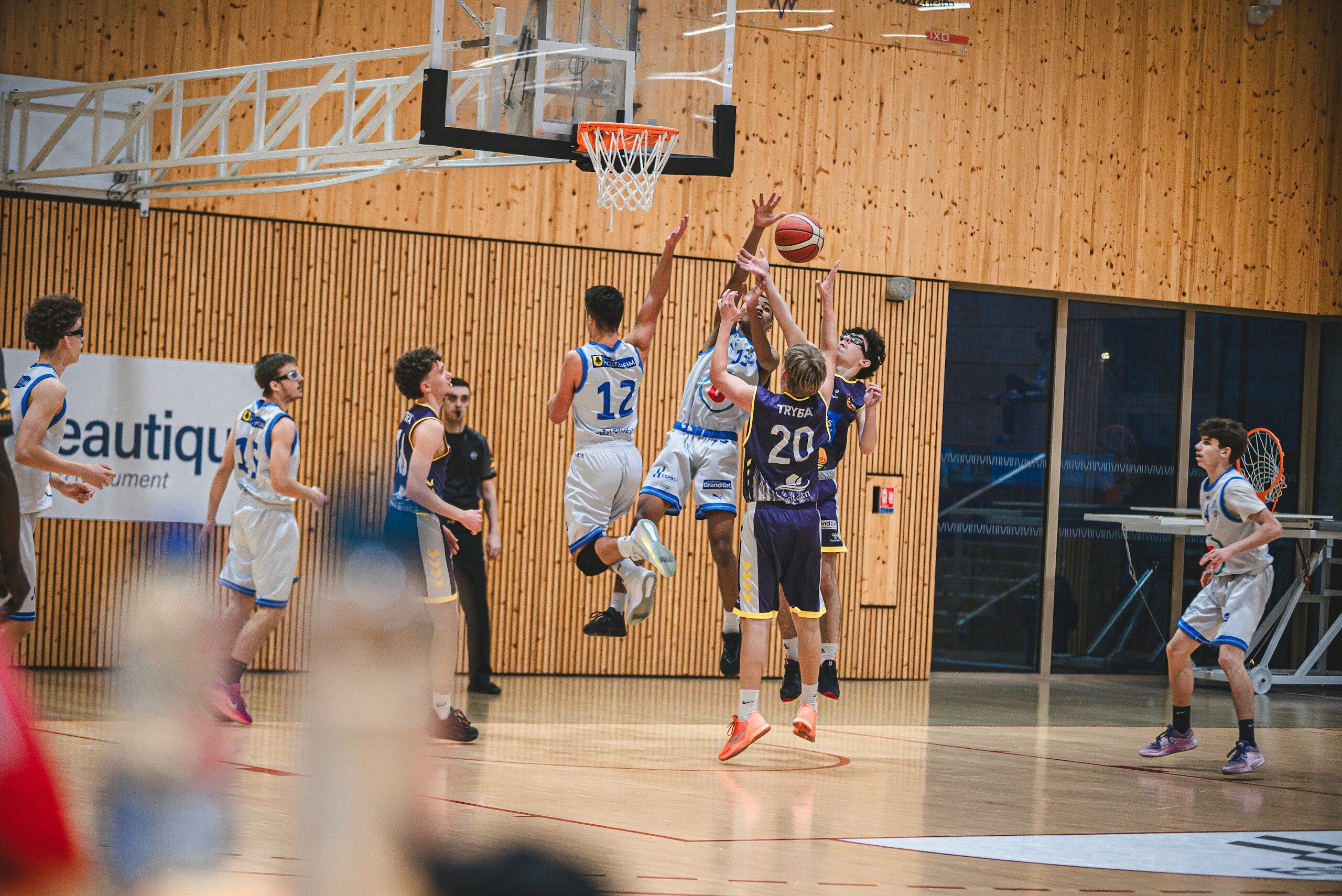 Basketball players jump for the ball during a game.