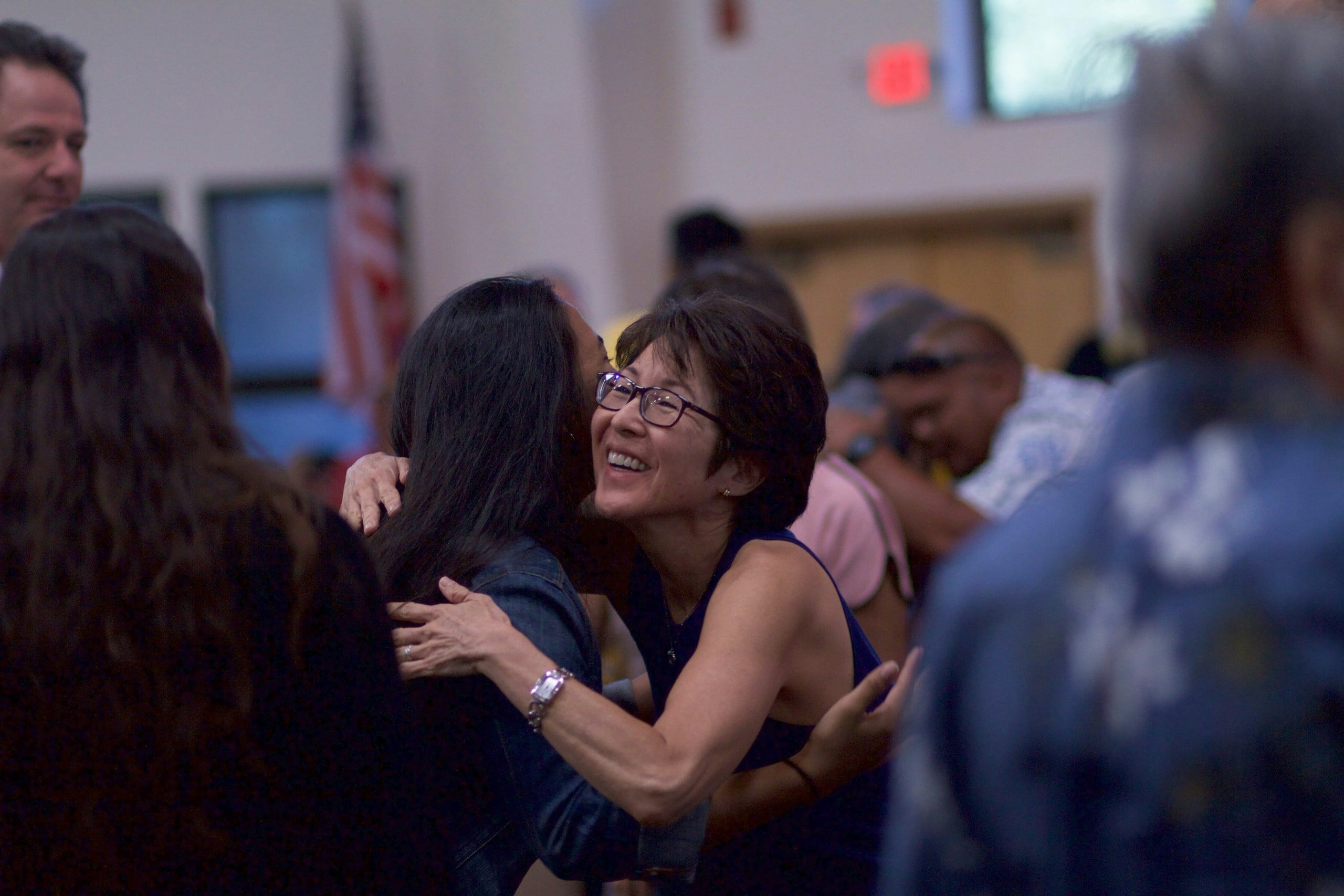 selective focus photography of two women hugging