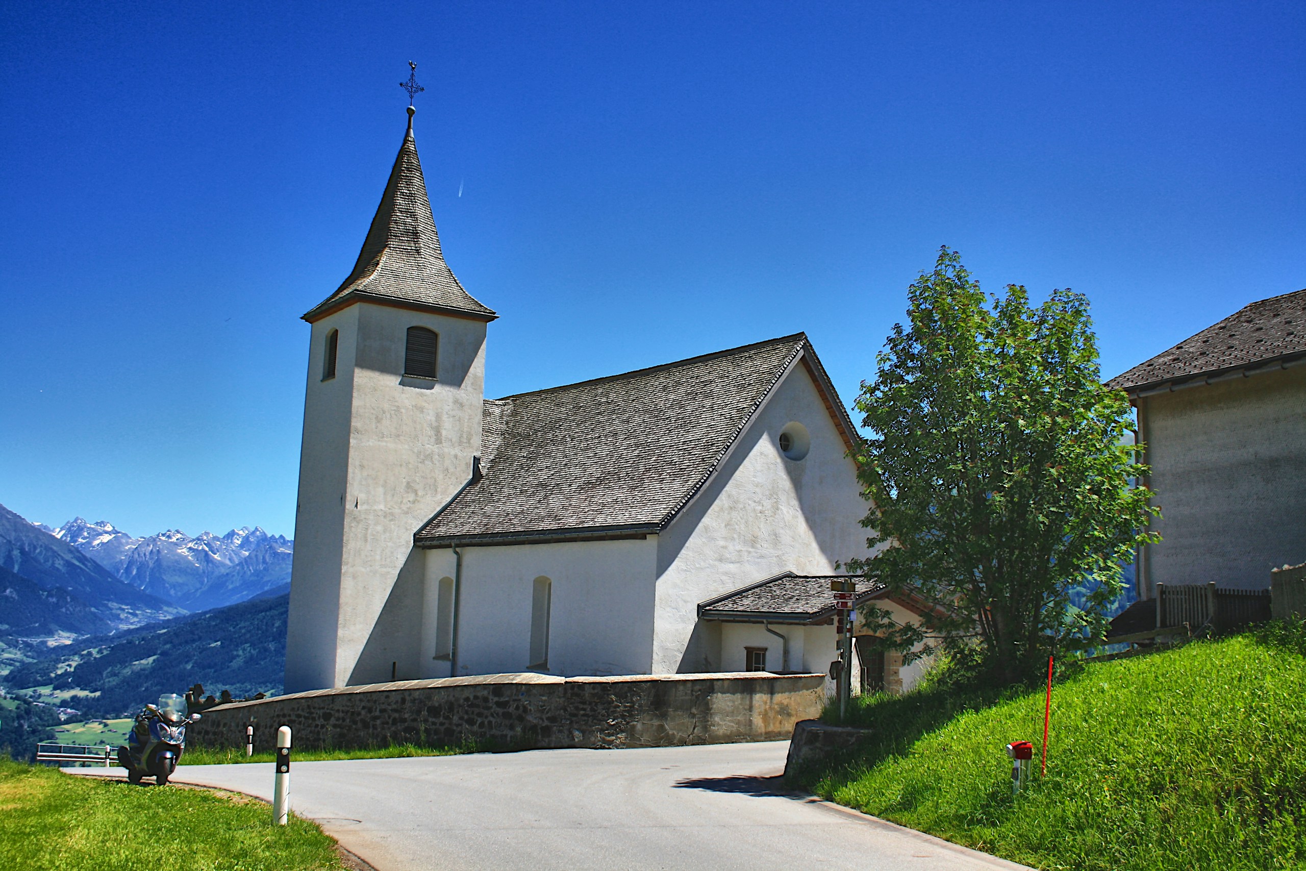 a white church with a steeple on a hill