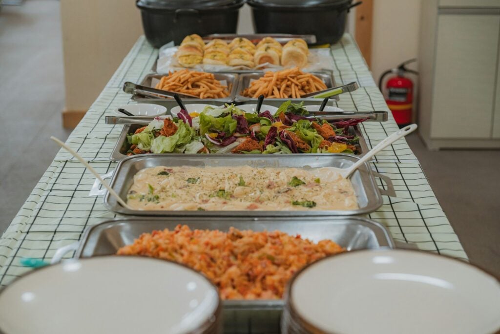 Buffet table with various dishes and salads