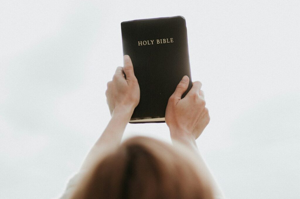 person holding Holy Bible