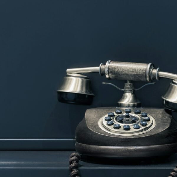 black and brown rotary phone near gray wall