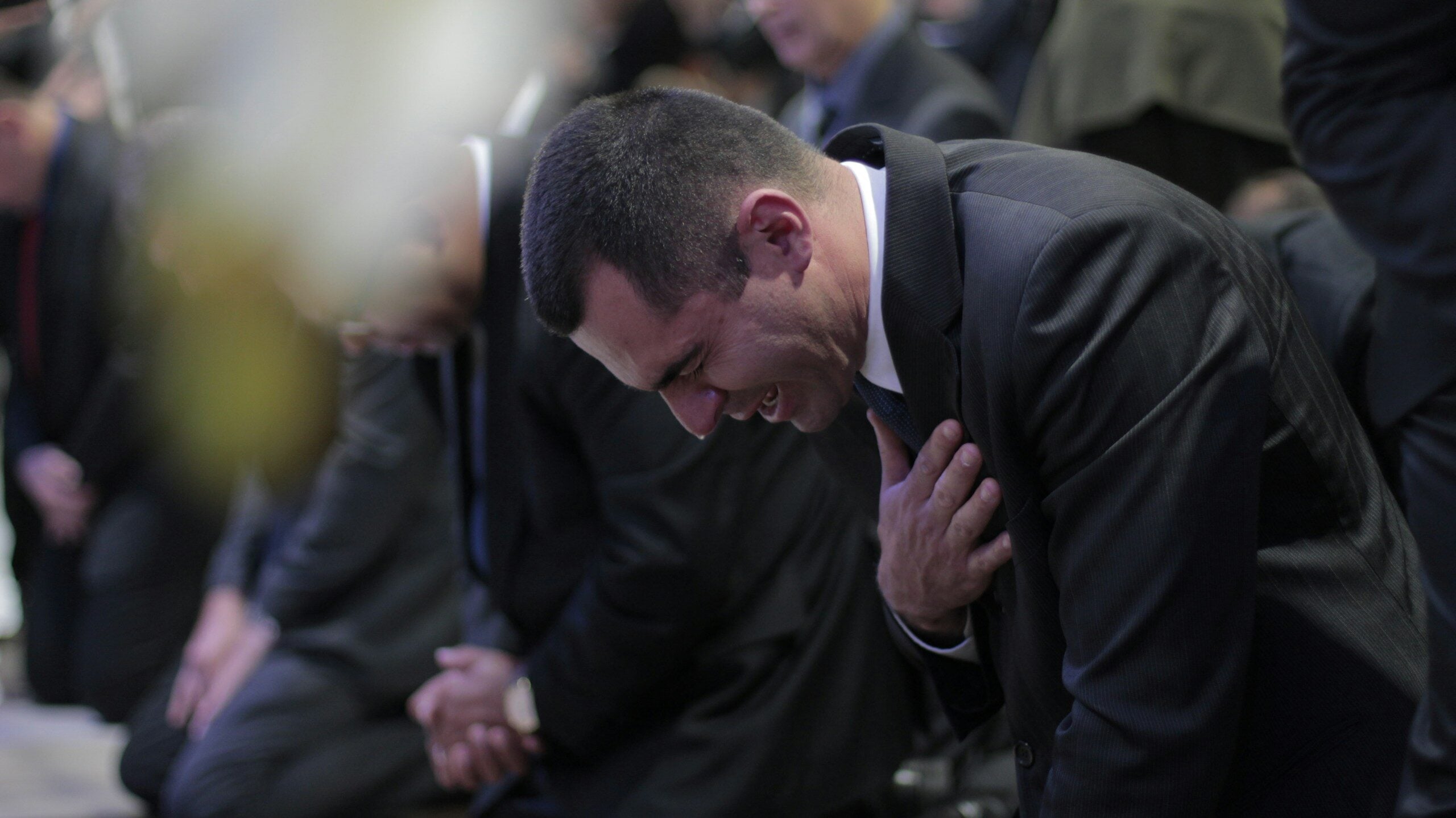 man bowing while crying