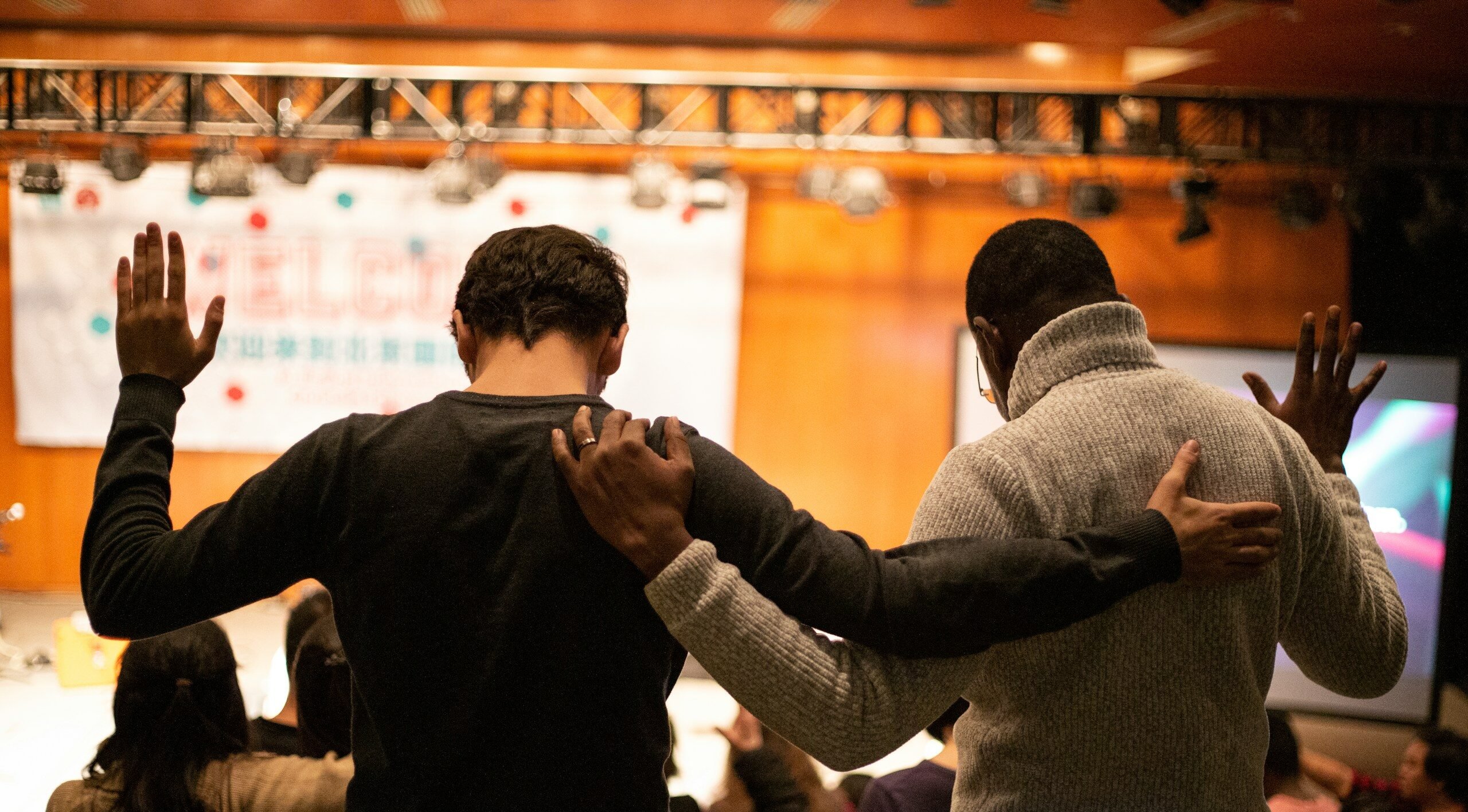 two men holding ear others hand