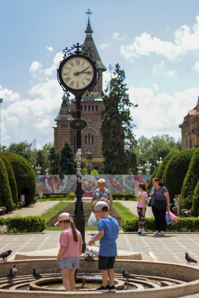a group of people standing around a clock tower