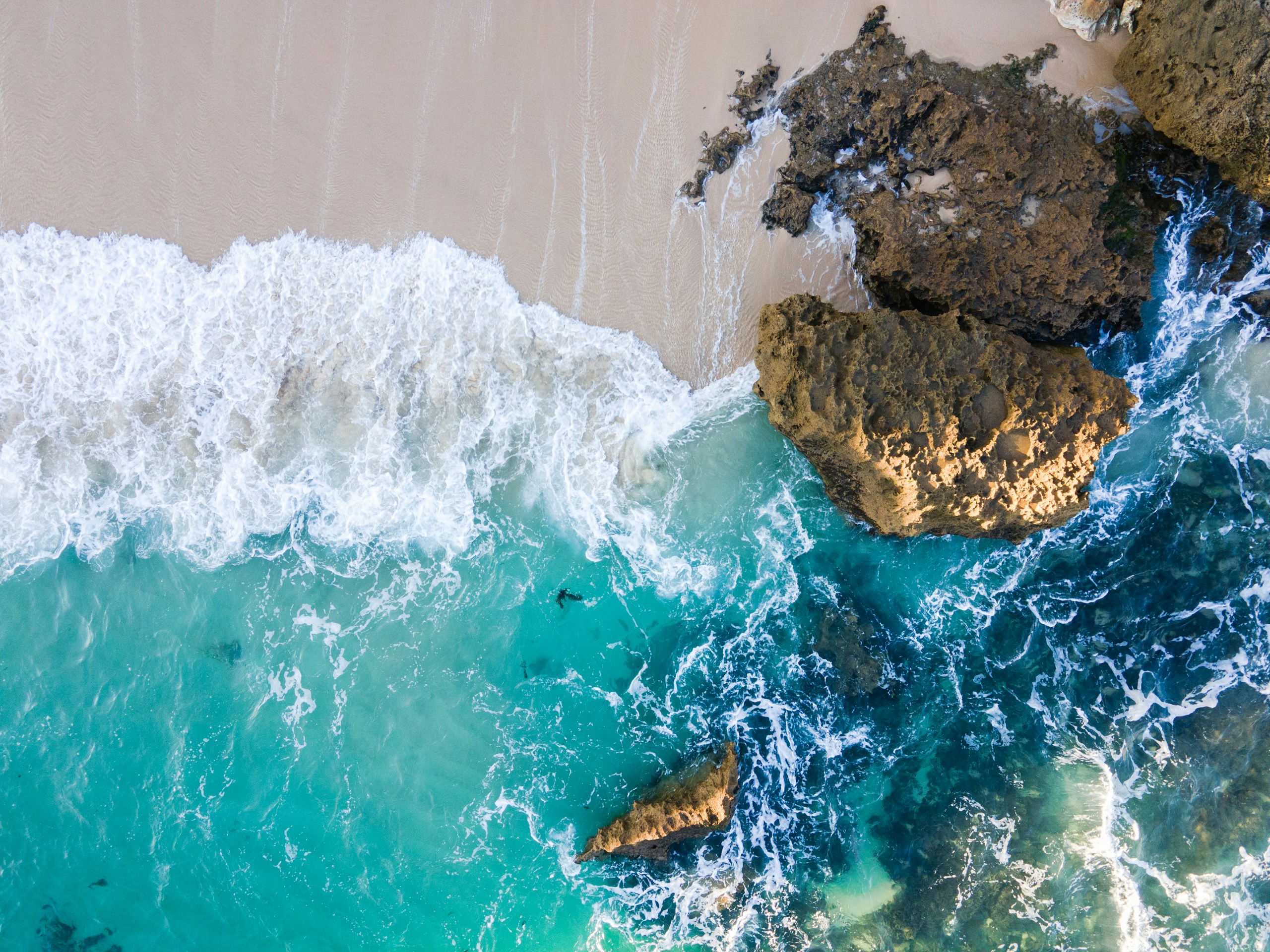 brown rock formation on body of water during daytime