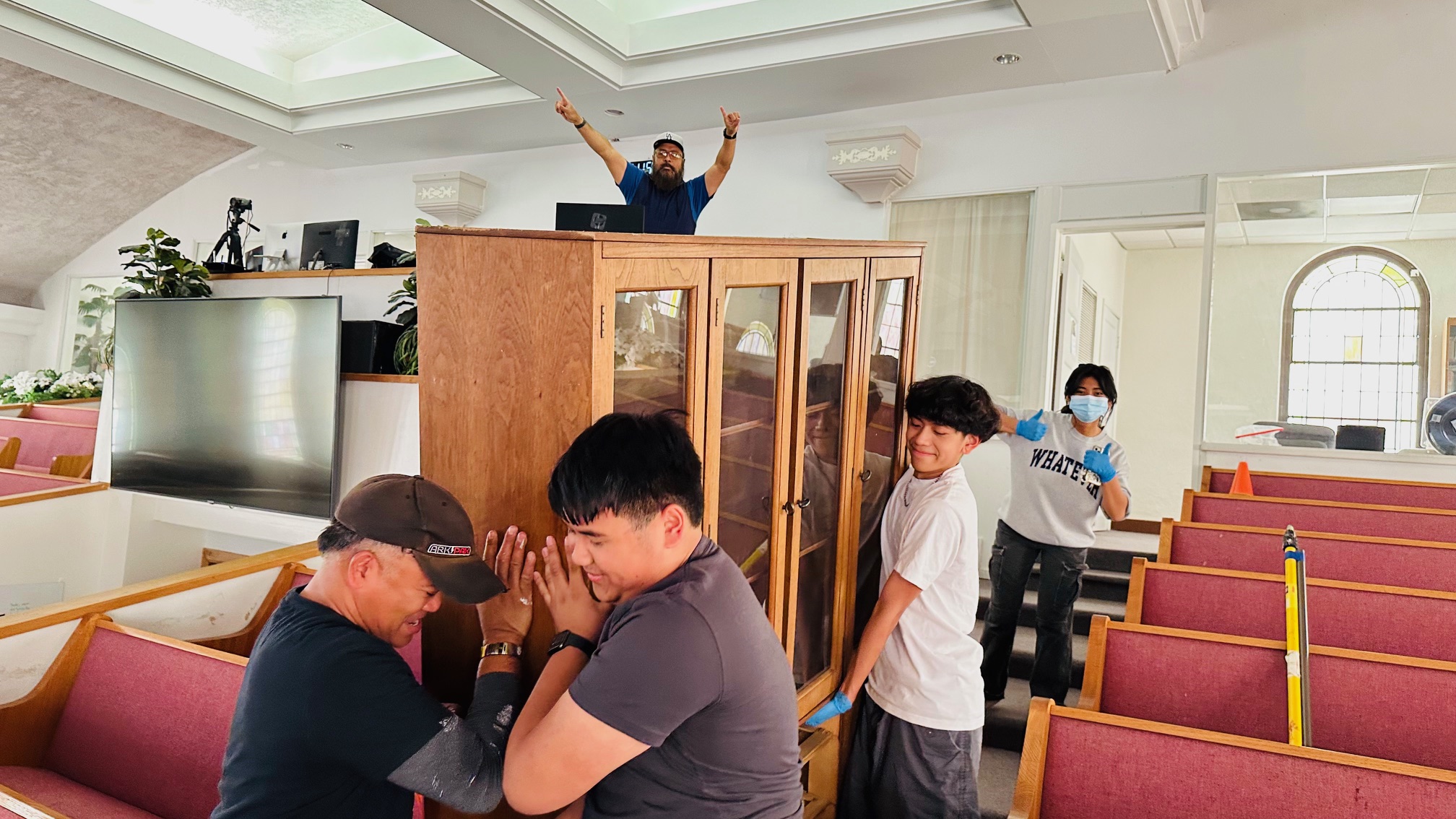 Group of young men moving a bookshelf.