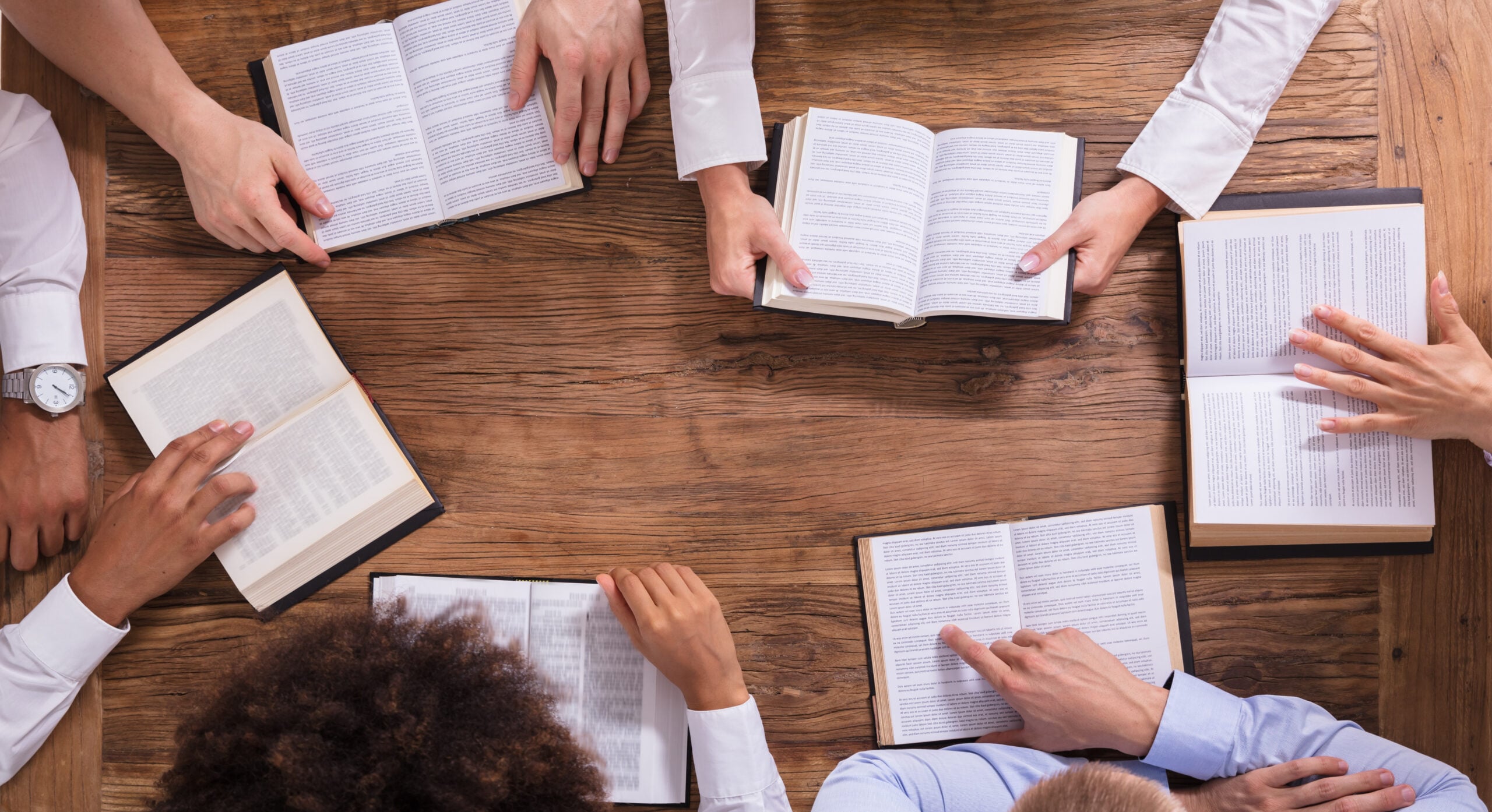 Elevated View Of People Reading Holy Bible On Wooden Background