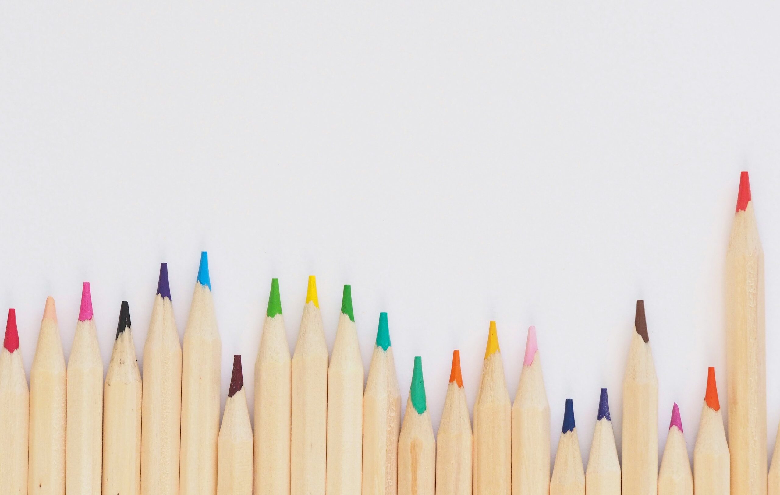 colored pencil lined up on top of white surface