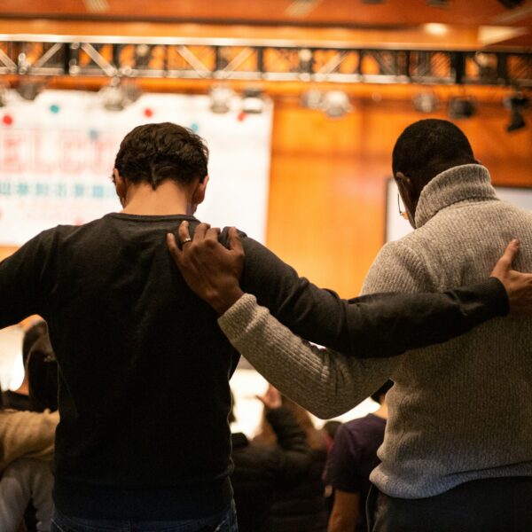 two men holding ear others hand