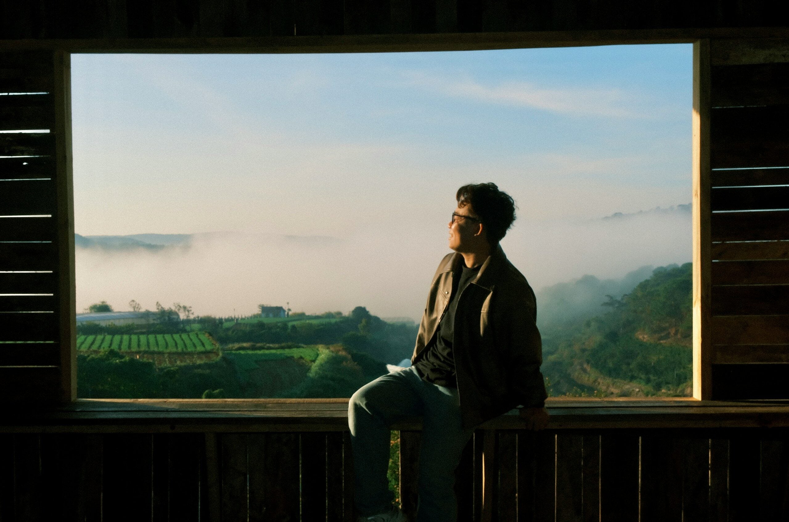 Man looking up at the sky from a wooden structure