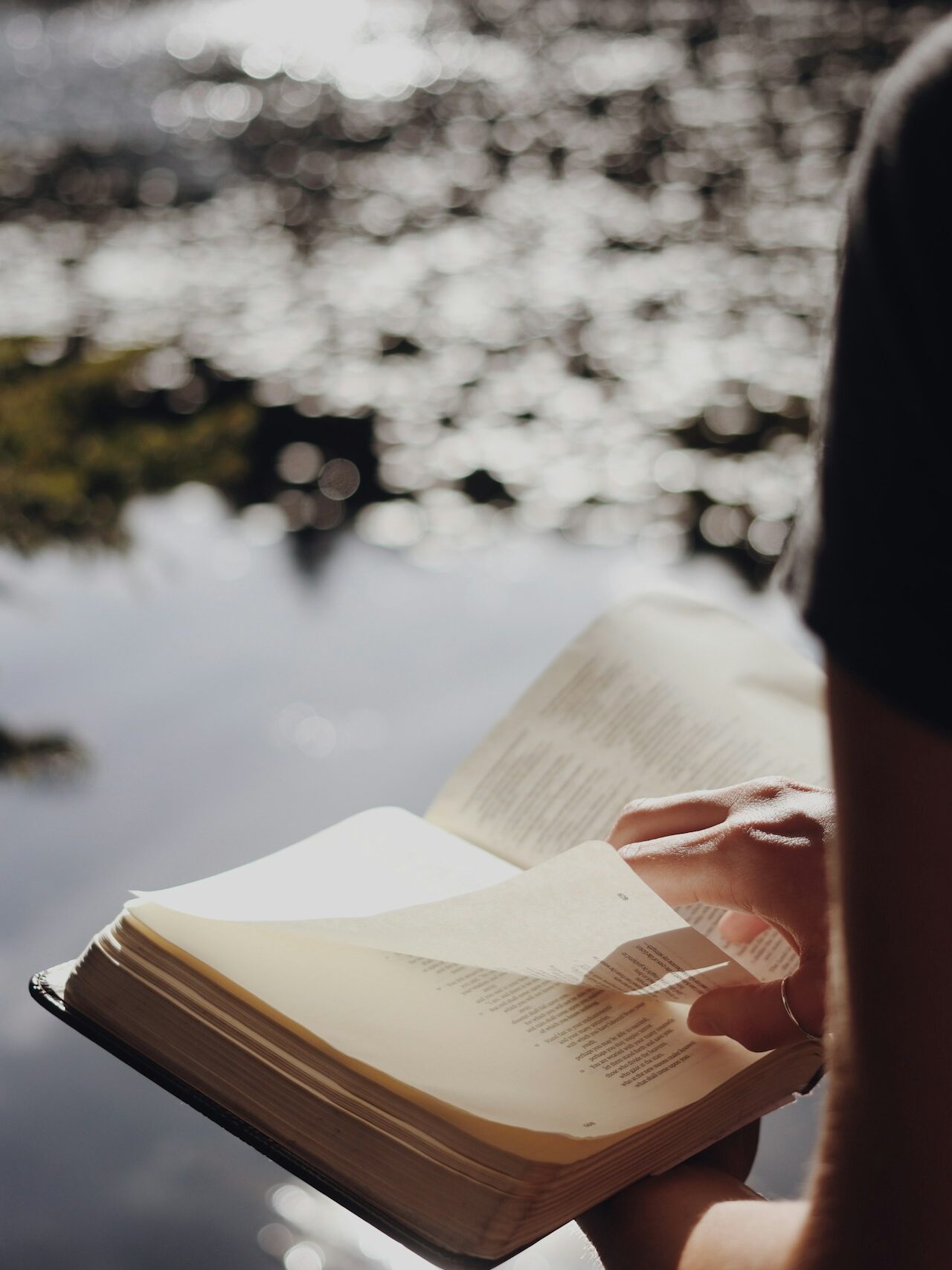 person in black long sleeve shirt holding book