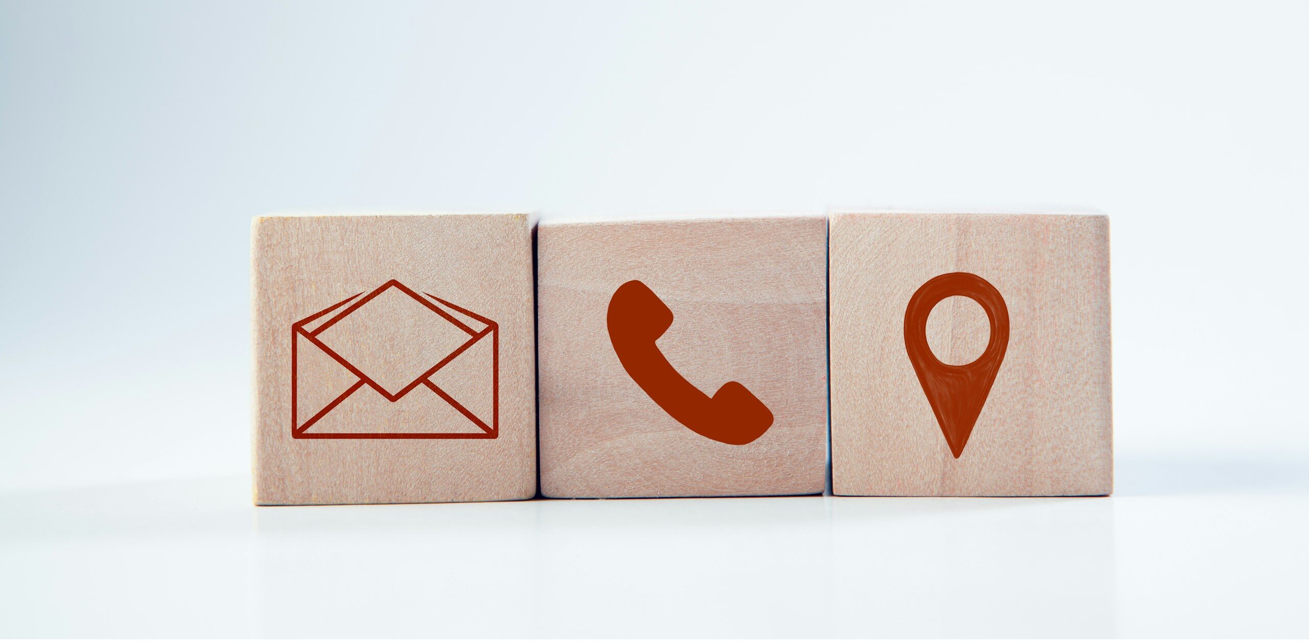Wooden blocks with contact icons: envelope, phone, location