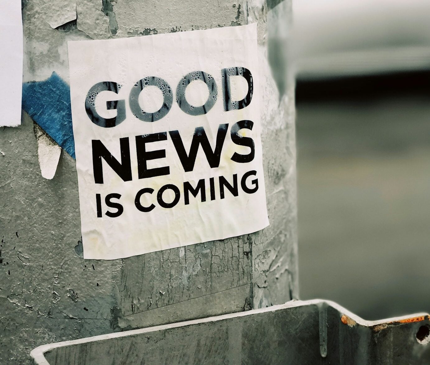 white Good News Is Coming paper on wall