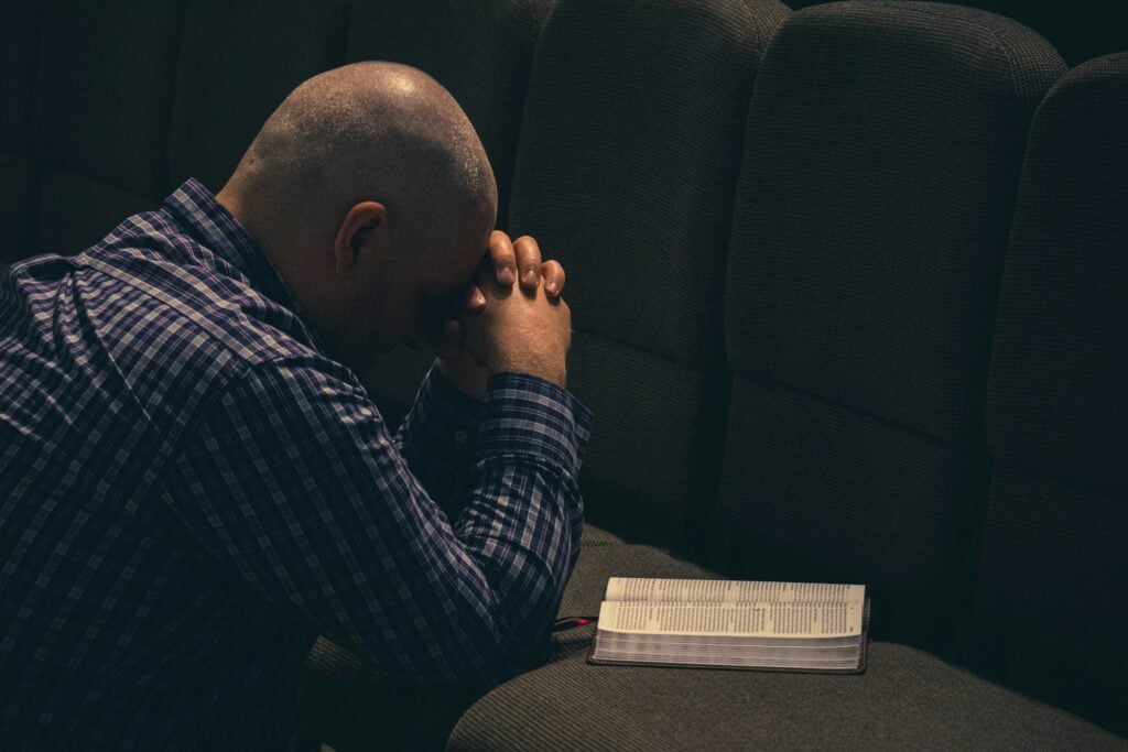 a man sitting on a couch with his hands on his face