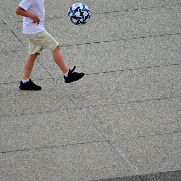 A young boy is kicking a soccer ball