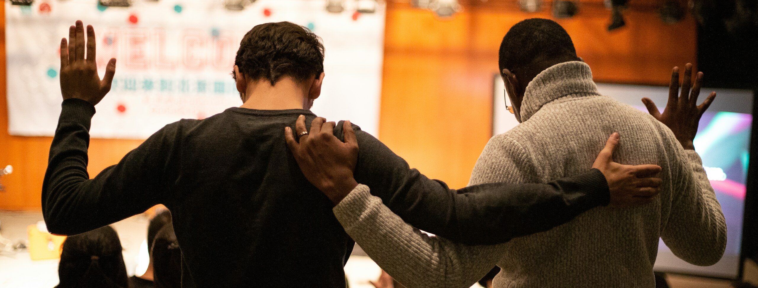 two men holding ear others hand