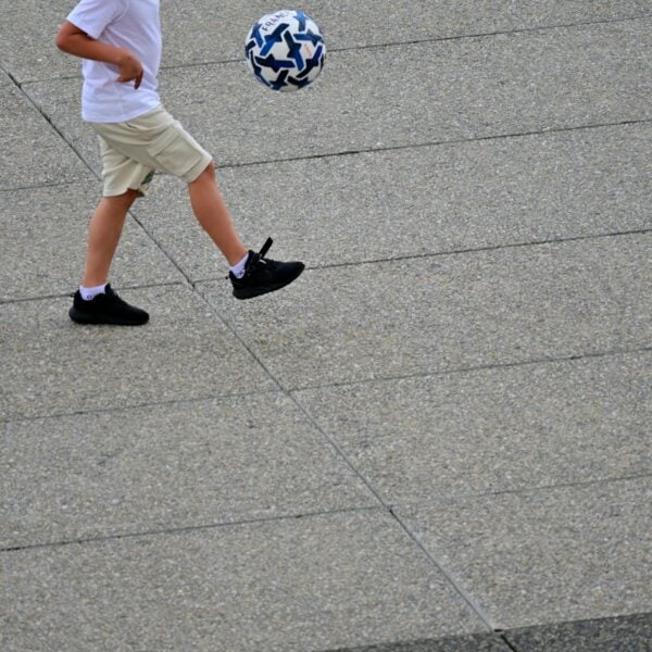 A young boy is kicking a soccer ball