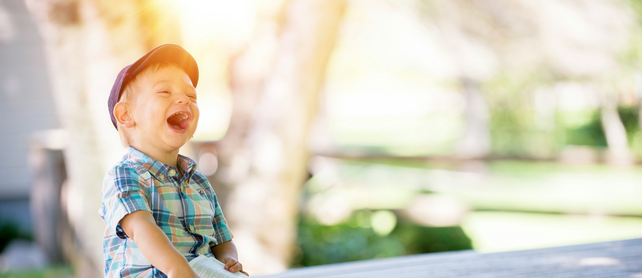 boy sitting on bench while holding a book