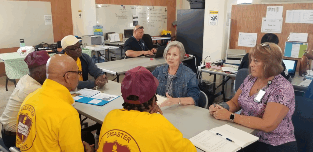 Representatives of the Federal Emergency Management Agency speak with volunteers of Adventist Community Services.