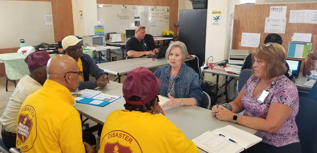 Representatives of the Federal Emergency Management Agency speak with volunteers of Adventist Community Services.