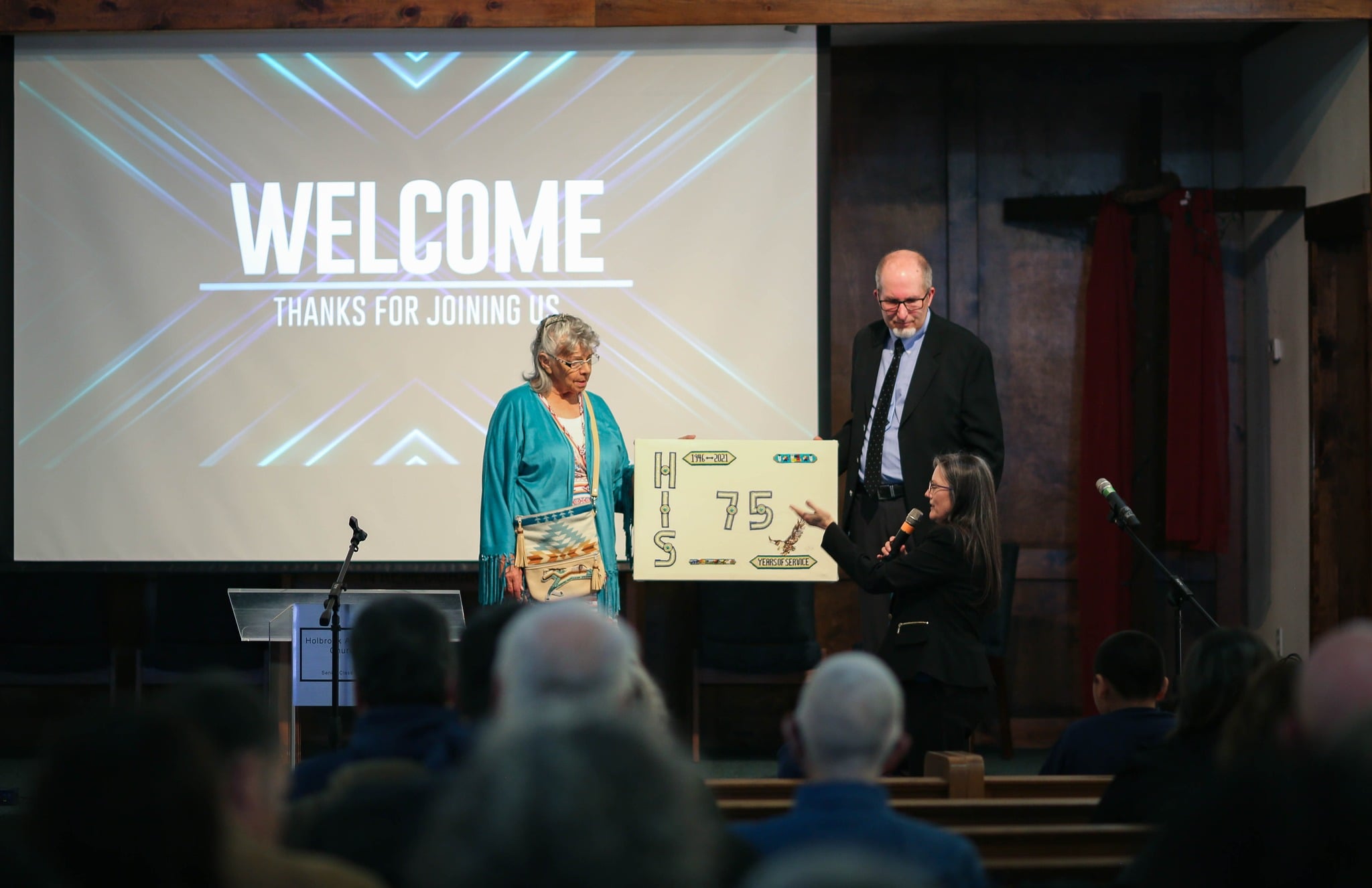 HIS volunteer Della Ault (left) presents the school with a gift to commemorate it&rsquo;s 75th anniversary Photo Credit &ndash; HIS Facebook Page