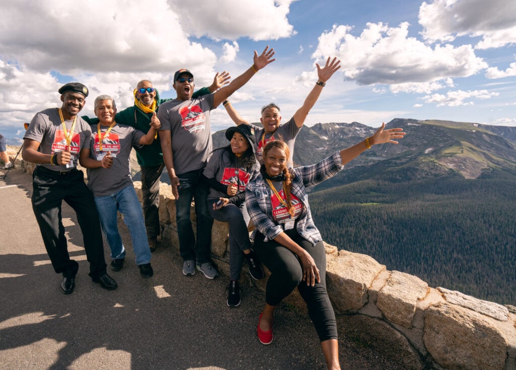A group of Master Guides wearing the official convention T-shirt celebrate at a mountain viewpoint. Photo by Pieter Damsteegt