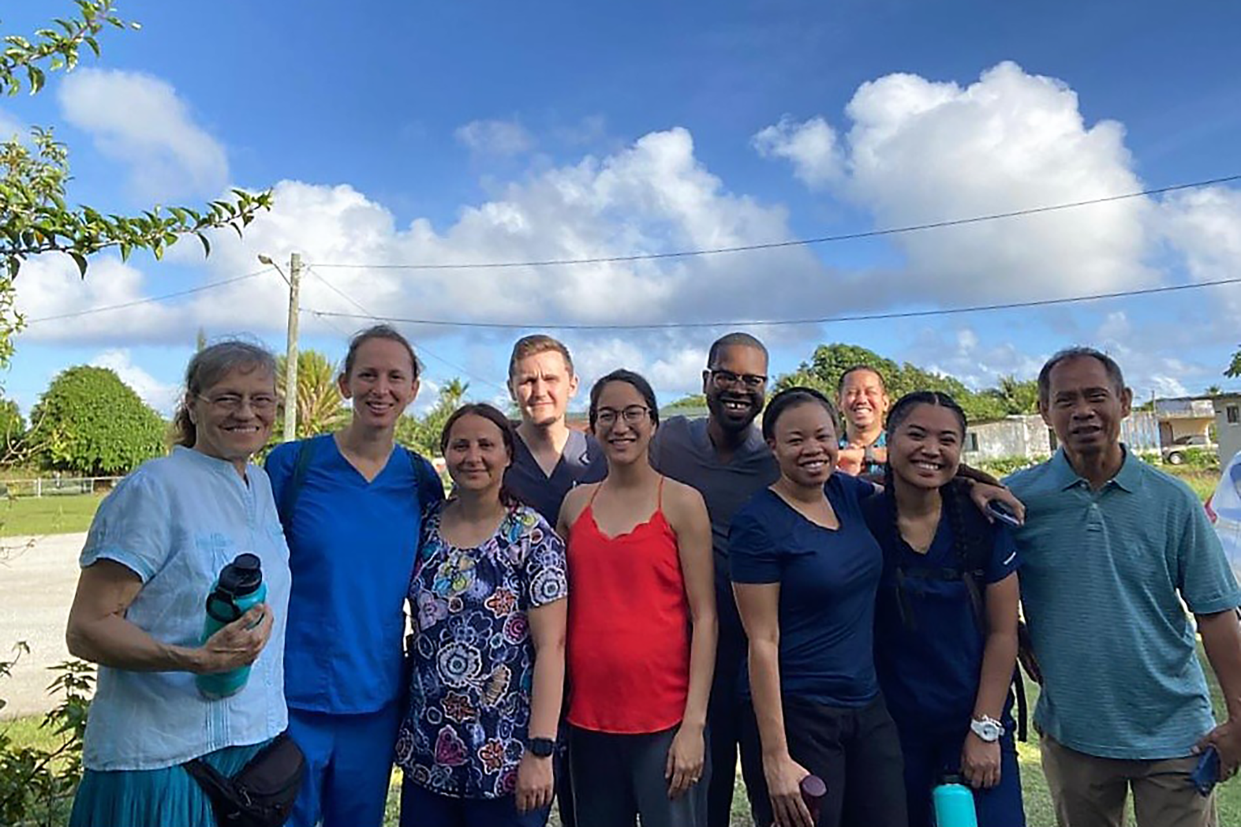 Group picture of individuals of different ages and races in a sunny outdoor setting