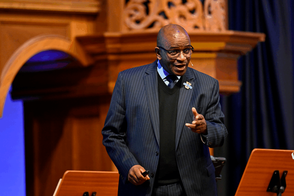 Close-up of black man in a suit speaking to an unseen crowd