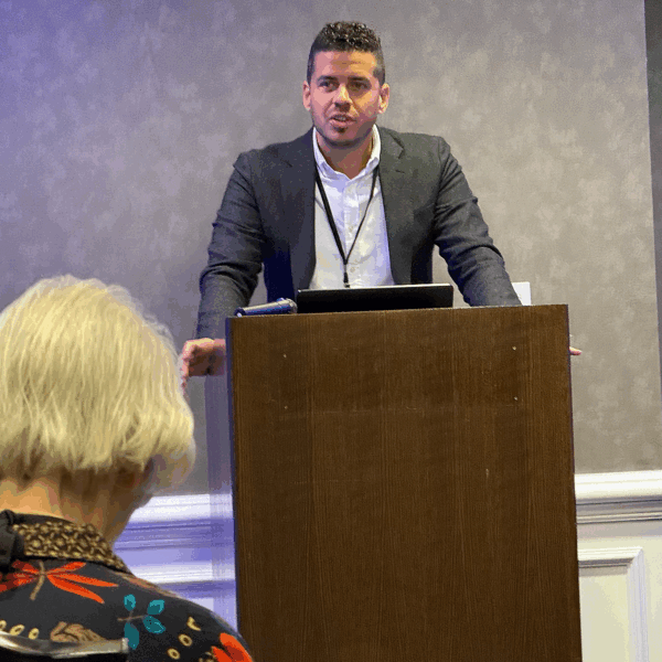 Hispanic man speaks at a podium