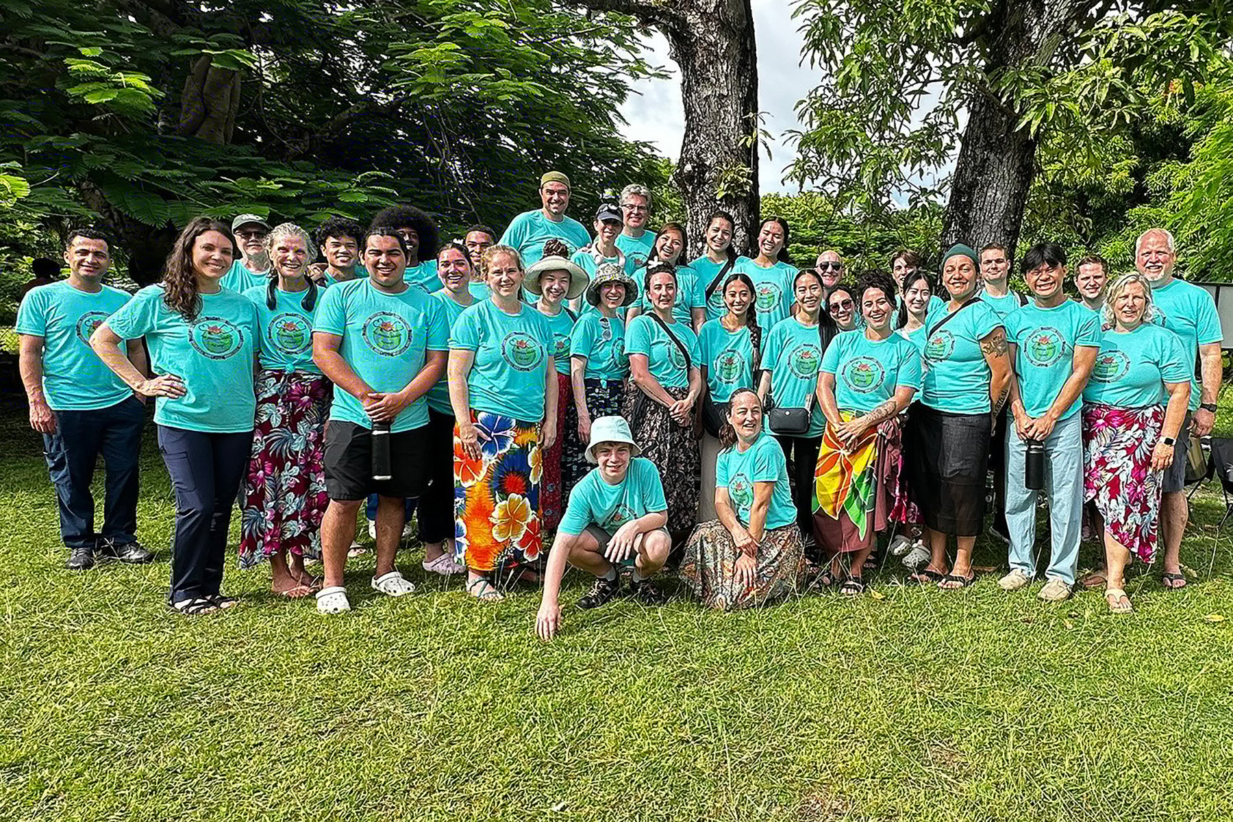Group photo of people in green t-shirts outside in Fiji
