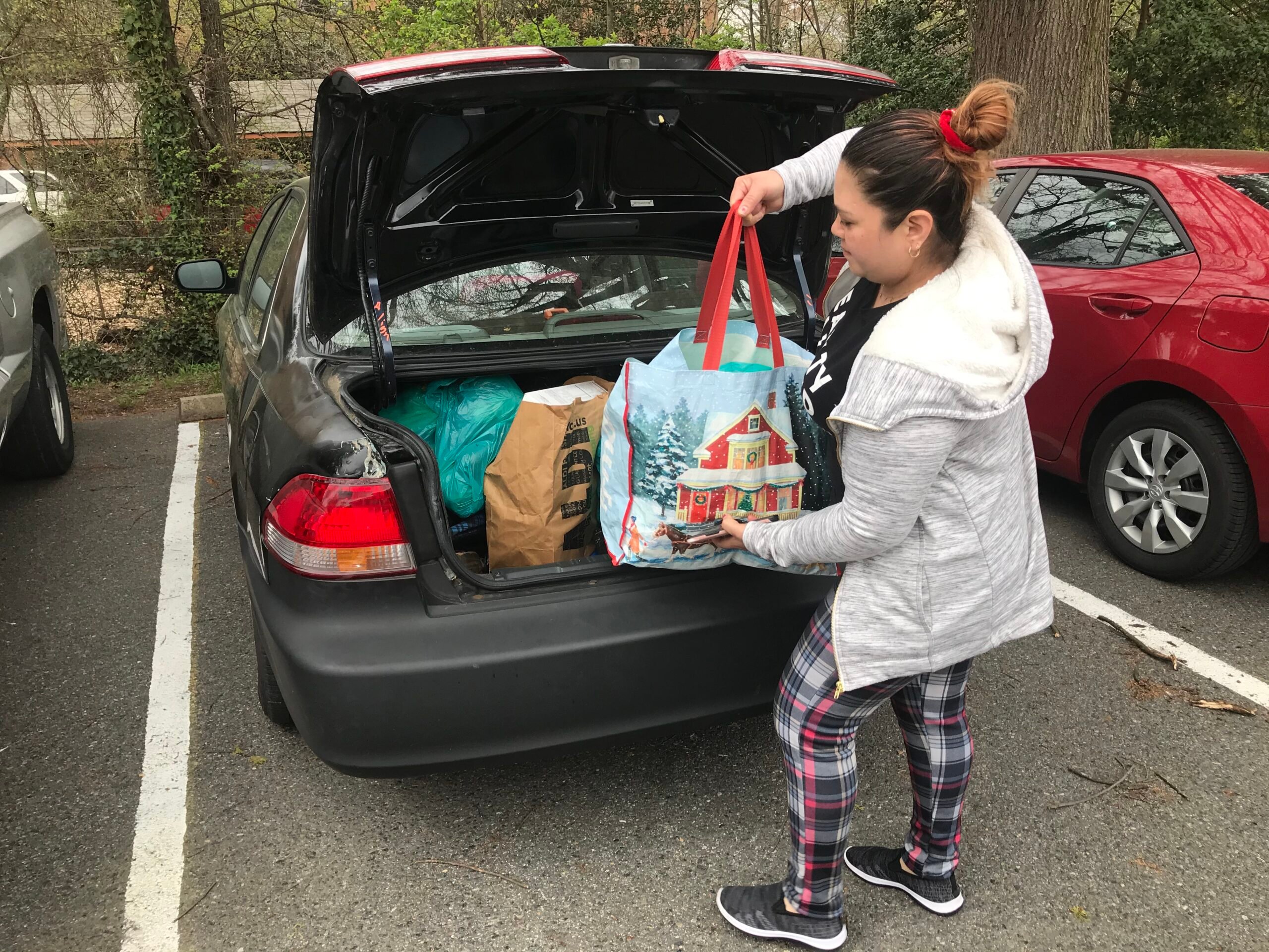 A woman loads up her trunk with food from Adventist Community Services Greater Washington for three families. 