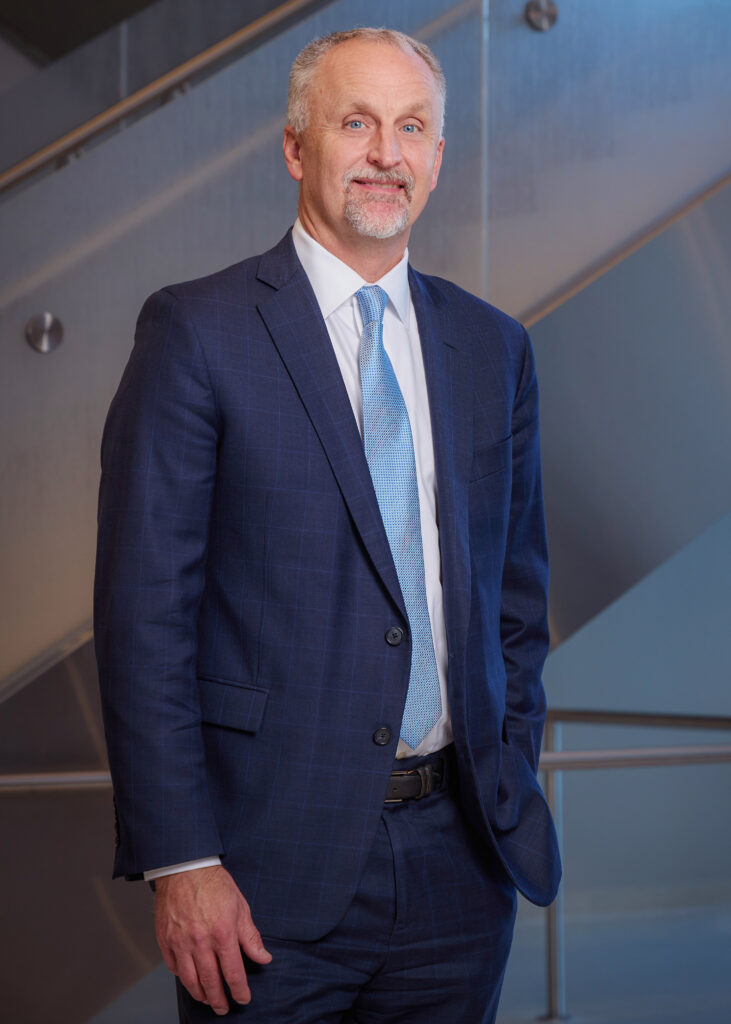 Man in suit smiling towards the camera.