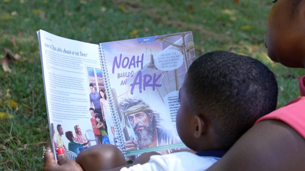 Mother and toddler son reading one of the stories in the new Sabbath School program