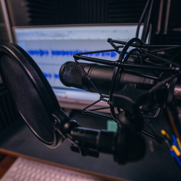Close up of radio station microphone, mixer, computer, sound board