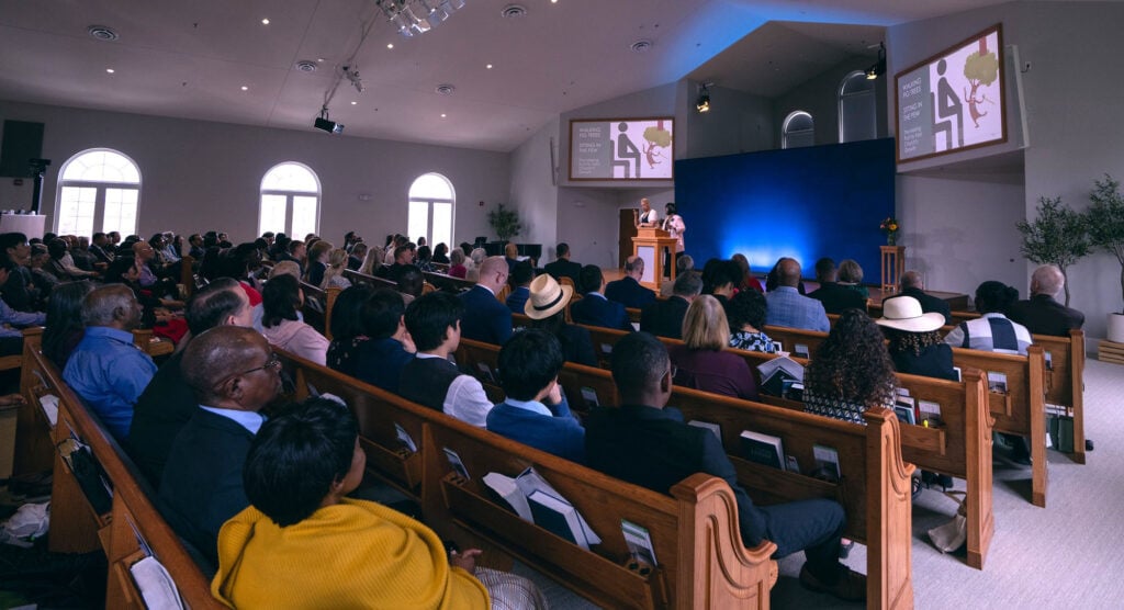 Photo of a church congregation watching a presentation about supporting members with disabilities.